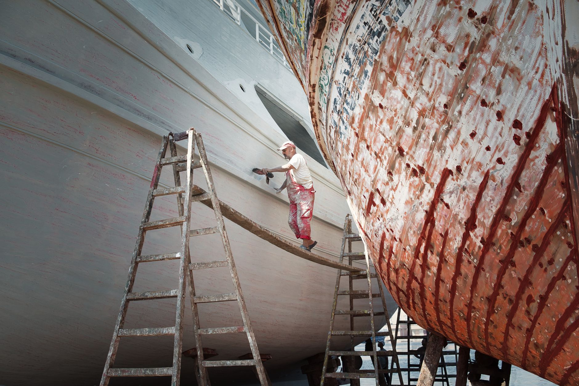 Craftsman applying traditional oakum caulking to a clinker-built boat seam as part of wooden boat restoration
